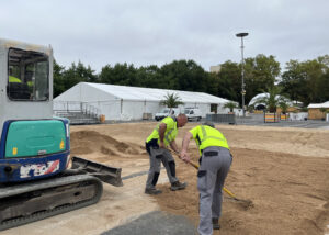 Les agents municipaux répartissent le sable de la plage sur la carrière accueillant les démonstrations